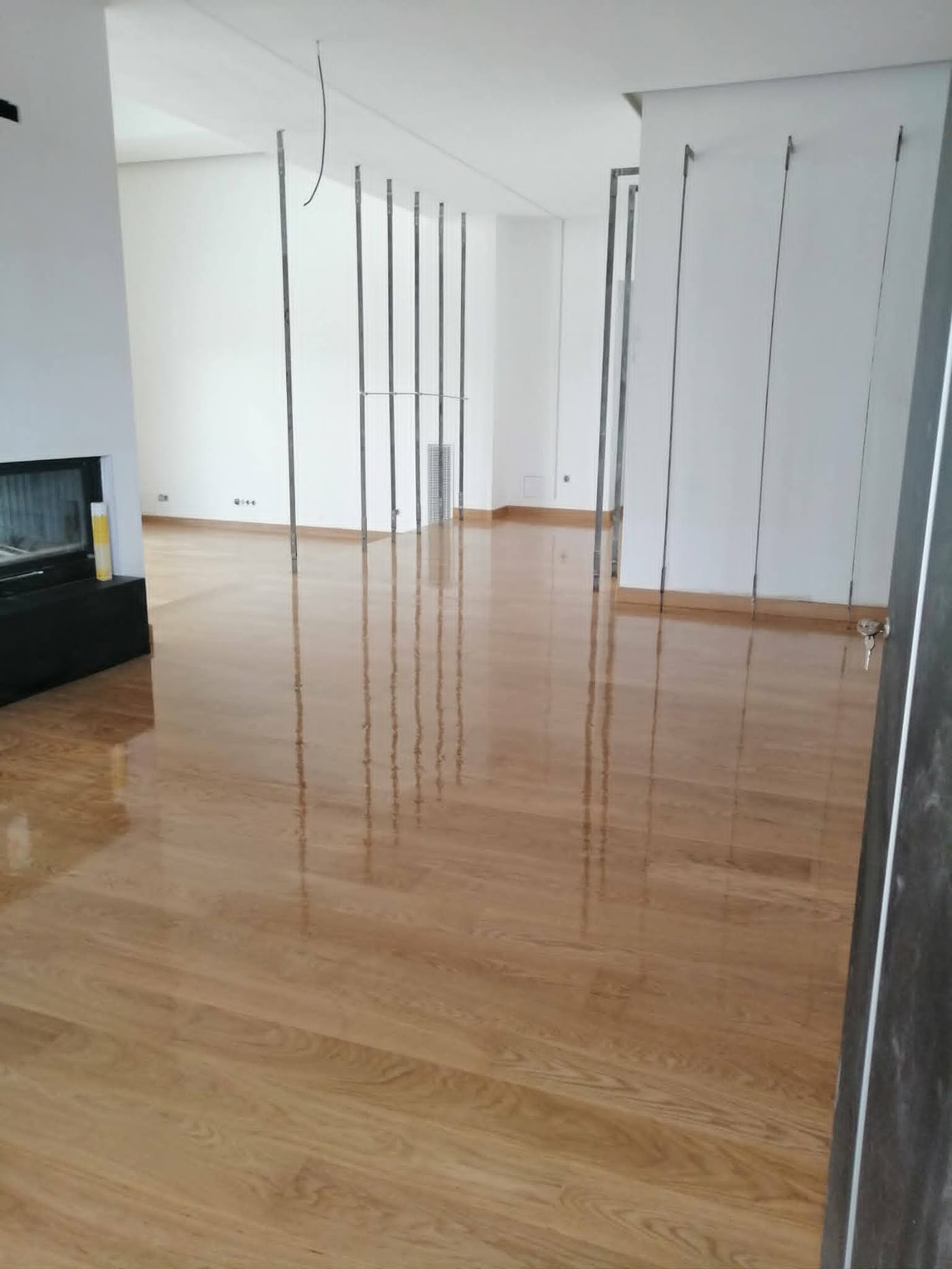 Γυαλιστερό ξύλινο δάπεδο σε σαλόνι, με αντανακλάσεις